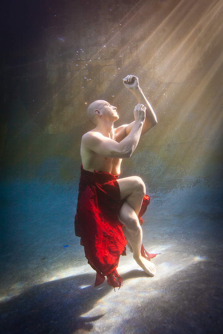 Underwater yoga wearing long red skirt. 