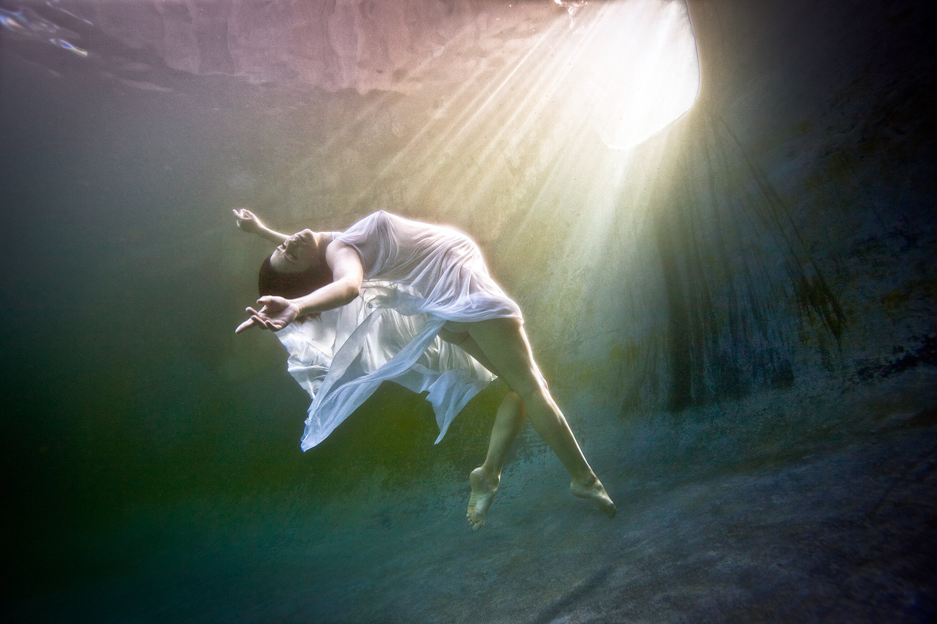 underwater floating pregnant woman in an enchanted pool